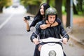 Happy tourist young couple on scooter ride in new city. Woman making photo on camera while riding outdoors Royalty Free Stock Photo