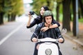 Happy tourist young couple on scooter ride in new city. Woman making photo on camera while riding outdoors Royalty Free Stock Photo