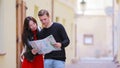 Happy tourist couple traveling on holidays in Europe smiling happy. Caucasian couple with citymap outdoors