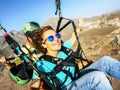 Happy tourist doing paragliding sport activity in outdoor leisure active lifestyle. Cheerful adult woman doing selfie picture Royalty Free Stock Photo