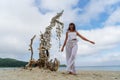 Happy tourist female in white dress posing with dry tree covered by seashells summer travel vacation Royalty Free Stock Photo