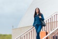 Smiling Woman Holding Travel Suitcase Arriving at Destination Royalty Free Stock Photo