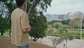 Happy tourist looking cityscape holding camera back view. Man taking picture Royalty Free Stock Photo