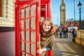 Happy tourist looking out of the red phonebox Royalty Free Stock Photo