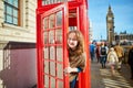 Happy tourist looking out of the red phonebox Royalty Free Stock Photo