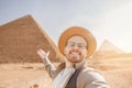 Happy tourist man in hat take selfie photo background pyramid of Egyptian Giza sunset, Cairo, Egypt Royalty Free Stock Photo