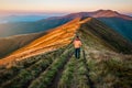 Happy tourist man hiking in mountains at sunrise Royalty Free Stock Photo