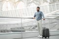 Happy Tourist Man Posing With Travel Suitcase At Modern Airport Royalty Free Stock Photo