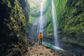 A happy tourist man watching Madakaripura Waterfall. The tallest waterfall in Java Island. Nature landscape background of travel