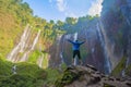 A happy tourist man watching Sewu Waterfall. The biggest waterfall in Java Island. Nature landscape background of travel trip and