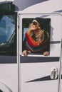 Happy tourist outside the camper van window enjoying destination. One woman smile and have fun admiring arrival travel on her