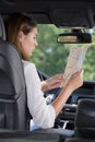 happy tourist reading map inside car on vacation Royalty Free Stock Photo