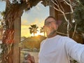 Happy tourist in summer holiday vacation take selfie picture with mobile cell outside a beach tropical restaurant. People and Royalty Free Stock Photo