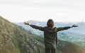 Happy tourist traveler standing on a rock with raised hands, hiker looking to a valley below in trip in spain, hipster young girl Royalty Free Stock Photo