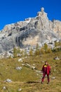 Happy tourist trekker girl in Dolomites mountains in autumn