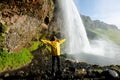 Happy tourist under Seljalandfoss waterfall