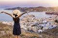 A happy tourist woman overlooks the city of Ermoupoli, Syros island