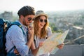 Happy tourists couple, friends sightseeing city with map together. Travel people concept. Royalty Free Stock Photo