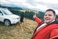 Happy tourists couple at peak of the hill with beautiful mountains at background. car travel Royalty Free Stock Photo