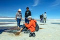 Happy tourists enjoy Jeep tour activities in Salt flats Salar de Uyuni in Bolivia