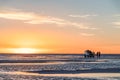 Happy tourists enjoy Sunset during four wheel tour in Salt flat Lake Salar de Uyuni in Bolivia