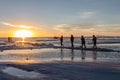 Happy tourists enjoy Sunset during four wheel tour in Salt flat Lake Salar de Uyuni in Bolivia