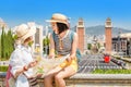 Happy tourists looking at the map while traveling in Barcelona, near Venetian Towers and Spain Square Royalty Free Stock Photo