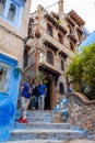 Happy tourists posing in front of a hotel in the Blue City, Chefchaouen, Morocco