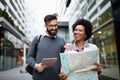 Happy tourists sightseeing city with map. Travel, people, fun concept Royalty Free Stock Photo