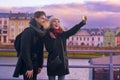 Happy tourists taking photo of themselves on smartphone. Holidays, travel, vacation, tourism and dating concept. Weeknd in Europe