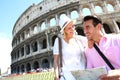 Happy tourists visiting Coliseum with map Royalty Free Stock Photo