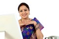 Happy traditional Indian business woman at office desk