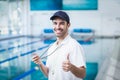 Happy trainer holding stopwatch with thumbs up