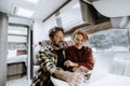 Happy travel couple lifestyle smile and use laptop together inside a modern camper van in vanlife offgrid alternative office