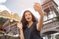 Beautiful young girl taking funny selfie with her mobile phone near the Eiffel tower. Royalty Free Stock Photo