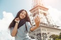 Beautiful young girl taking funny selfie with her mobile phone near the Eiffel tower. Royalty Free Stock Photo