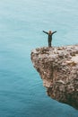 Happy traveler on cliff above sea hands raised Travel Lifestyle success motivation concept adventure active Royalty Free Stock Photo