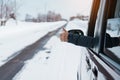 Happy Traveler driving car on snowy road and gesture finger up, woman Tourist enjoying snow forest view from the car window in Royalty Free Stock Photo