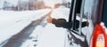 Happy Traveler driving car on snowy road and gesture finger up, woman Tourist enjoying snow forest view from the car window in Royalty Free Stock Photo