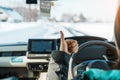 Happy Traveler driving car on snowy road and gesture finger up, woman Tourist enjoying snow forest view from the car in winter Royalty Free Stock Photo