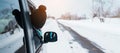 Happy Traveler driving car on snowy road, woman Tourist enjoying snow forest view from the car window in winter season. Winter Royalty Free Stock Photo