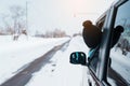 Happy Traveler driving car on snowy road, woman Tourist enjoying snow forest view from the car window in winter season. Winter Royalty Free Stock Photo