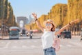 Traveler girl in the background of the traffic on Avenue Champs elysÃÂ©es. Tourism and students in France and Paris