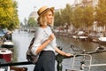 Happy traveler girl enjoying Amsterdam city. Smiling woman looking to the side on Amsterdam canal, Netherlands, Europe Royalty Free Stock Photo