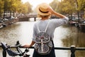 Happy traveler girl enjoying Amsterdam city. Tourist woman looking to the Amsterdam canal, Netherlands, Europe Royalty Free Stock Photo