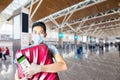 Happy traveler hugging his luggage with digital vaccine passport ready at the airport