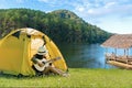 Happy traveler lifestyle women on vacation camping with tents playing guitar in the forest near river. Royalty Free Stock Photo