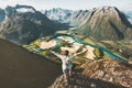 Happy traveler man raised arms standing on cliff over mountains Royalty Free Stock Photo