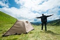 Happy traveler in the mountains near the tent Royalty Free Stock Photo