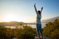 Happy traveler with open arms stands on the rock Royalty Free Stock Photo